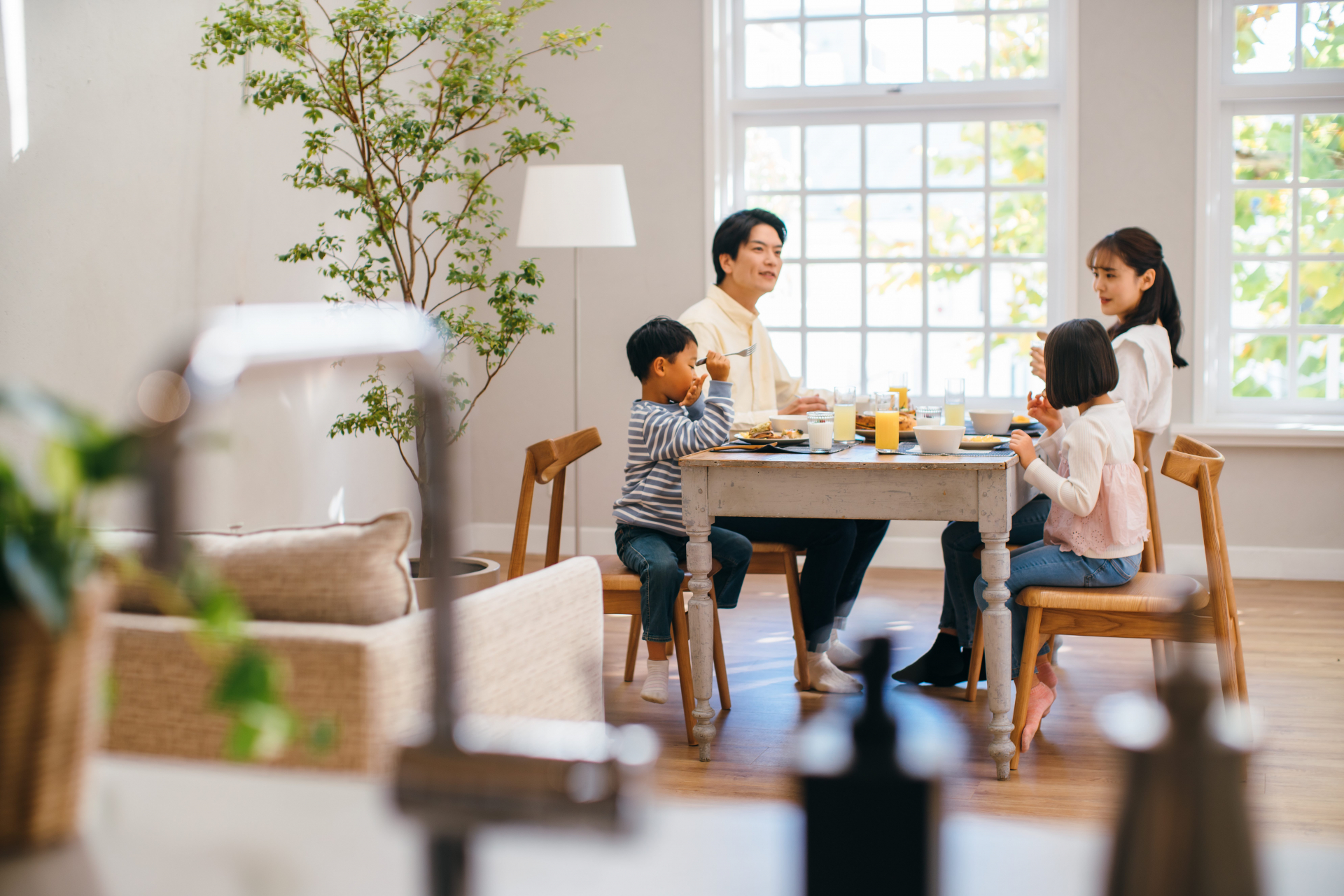 4人家族がテーブルで朝食を食べている様子